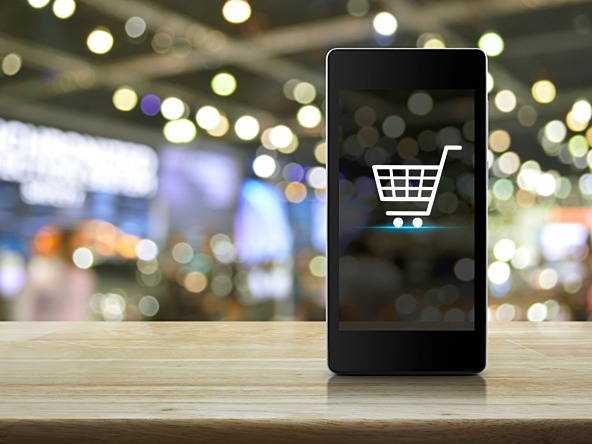 phone with a shopping basket and lights in background
